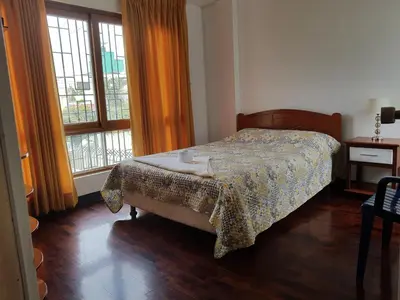 a bedroom with a bed and two windows at EL ENSUEÑO in Lima