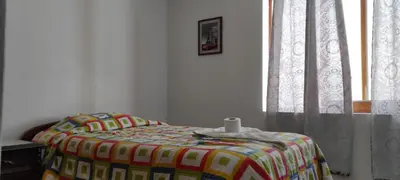 a bedroom with a bed with a blanket and a window at EL ENSUEÑO in Lima