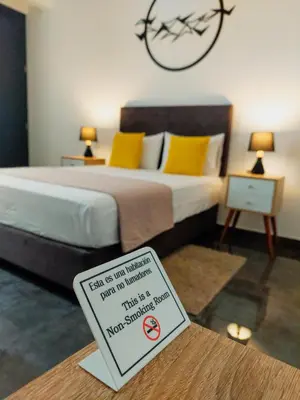 a hotel room with a bed with a sign on a table at Mandala in Pisco