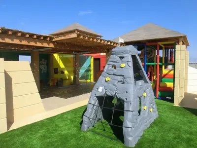 a playground with a rock wall in the grass at Aranwa Paracas Resort & Spa in Paracas