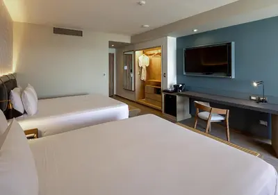 a hotel room with two beds and a flat screen tv at Aranwa Paracas Resort & Spa in Paracas