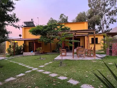 a house with a table and chairs in the yard at Bungalows de Casa Verde in Mala