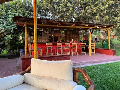 a patio with chairs and a table and a bar at Bungalows de Casa Verde in Mala