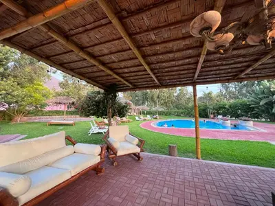 a patio with a couch and chairs and a pool at Bungalows de Casa Verde in Mala