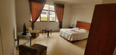 a bedroom with a bed and a chair and a window at Waldorf in Lima