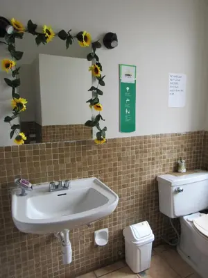 a bathroom with a sink and flowers on the wall at Waldorf in Lima