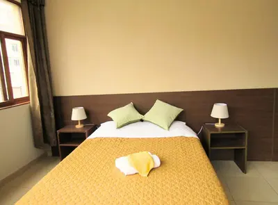 a bedroom with a bed with yellow sheets and pillows at Waldorf in Lima