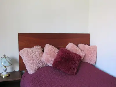 a pile of pink and purple pillows on a bed at Residencial Waldorf in Lima