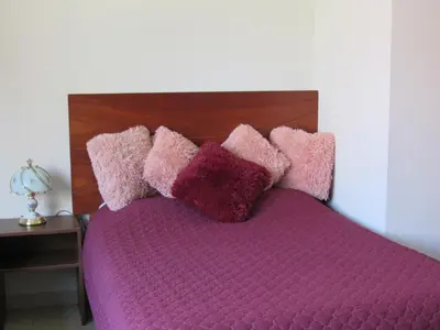 a bed with pink and purple pillows on it at Residencial Waldorf in Lima