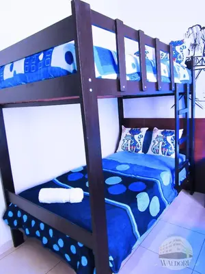 a bunk bed with blue and white pillows on it at Residencial Waldorf in Lima