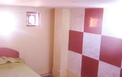 a bedroom with a red and white checkered wall at Hospedaje Pumacurco Betty in Cusco