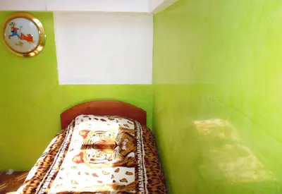 a small room with a bed in a green wall at Hospedaje Pumacurco Betty in Cusco