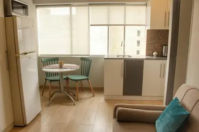 a kitchen with a small table and chairs in a room at Lindo y moderno Excelente ubicación in Lima