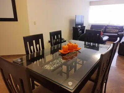 a dining room with a glass table with oranges on it at suite pardo CAA Miraflores in Lima