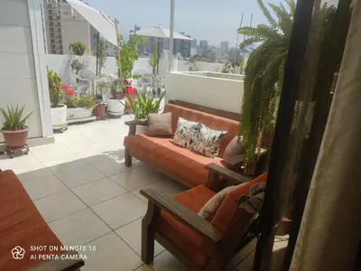 a balcony with a couch and plants on a building at Habitación RRB in Lima