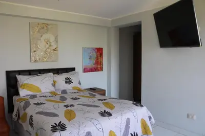a bedroom with a bed and a flat screen tv at Los Naturales in Huaral