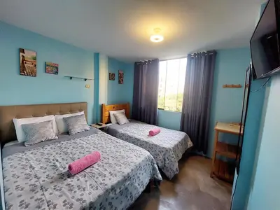 a bedroom with two beds with pink pillows at EL TUMI - Aeropuerto in Lima