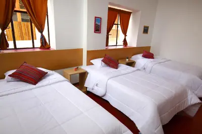 three beds in a room with windows at CASONA TORDO - A 3 Cdras de la Plaza - Habitaciones con baño privado in Cusco