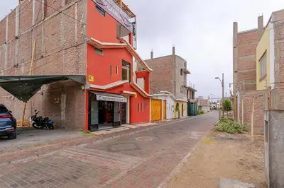 an empty street in an old town with a red building at Hospedaje Muñoz in Ica