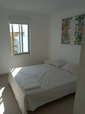 a bed in a white room with a window at Paracas top tower beach front in Paracas