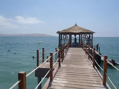 a wooden pier with a gazebo on the water at Paracas top tower beach front in Paracas