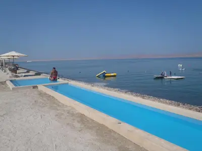 two swimming pools on the beach next to the water at Paracas top tower beach front in Paracas
