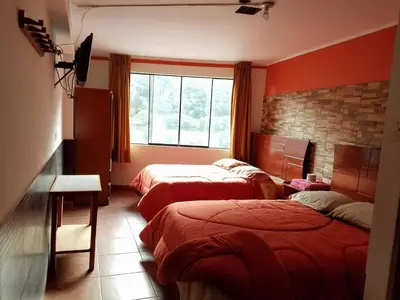 a hotel room with two beds and a window at Hotel Manantial in Churín