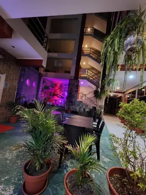 a lobby with a table and chairs and plants at Hotel Manantial in Churín