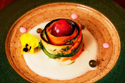 a plate of food with vegetables on a table at Las Qolqas EcoResort Ollantaytambo in Ollantaytambo