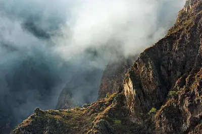 a view of a mountain with clouds in the sky at Las Qolqas EcoResort Ollantaytambo in Ollantaytambo
