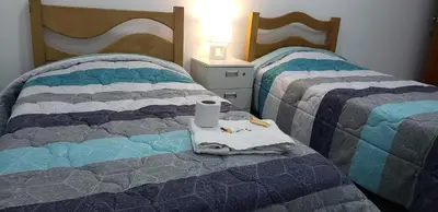 two beds with a towel and a cup on the bed at Hospedaje Pueblo Viejo in Casa Blanca