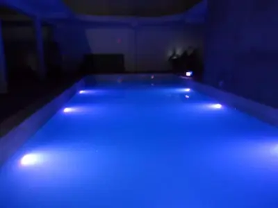 a blue pool with lights in a dark room at Hospedaje Pueblo Viejo in Casa Blanca