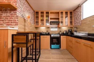 a kitchen with wooden cabinets and a brick wall at luxury Andino Ciudad real & 1 bed in Lima
