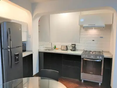 a kitchen with a stainless steel refrigerator and a table at Miraflores Kennedy's Park Apartment in Lima
