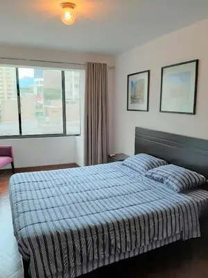 a hotel room with a bed and a window at Miraflores Kennedy's Park Apartment in Lima