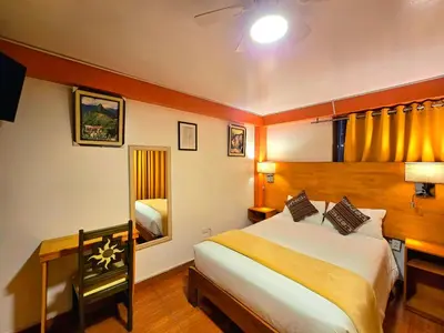 a bedroom with a large bed and a mirror at Amakonkay Machupicchu in Machu Picchu