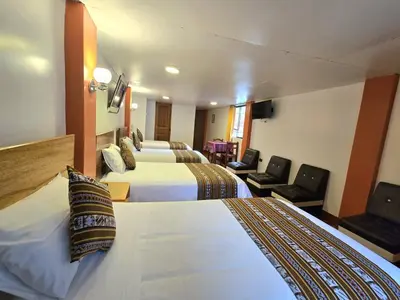 a hotel room with two beds and a television at Amakonkay Machupicchu in Machu Picchu