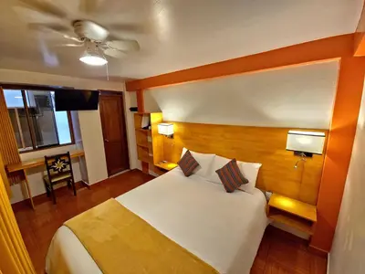 a hotel room with a bed and a ceiling fan at Amakonkay Machupicchu in Machu Picchu