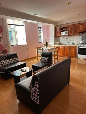a living room with two couches and a kitchen at Departamento Don Santiago Centro in Cusco