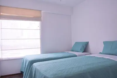 two beds sitting next to a window in a room at KYRA APARTMENTS - Central Miraflores - Spacious 4BR for 07 guests in Lima