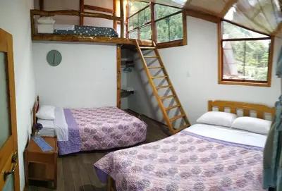 two beds in a room with two bunk beds at FRANKFURTER HOF FAMILIAR Oxapampa in Oxapampa