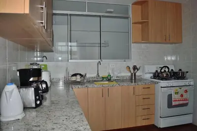 a kitchen with a sink and a stove at Apartamentos Las Americas in Lima
