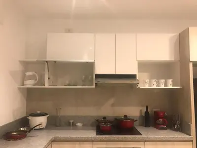 a kitchen with white cabinets and red pots on the counter at Vive - Descansa - Disfruta in San Bartolo
