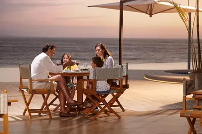 a family sitting at a table on the beach at Vive - Descansa - Disfruta in San Bartolo