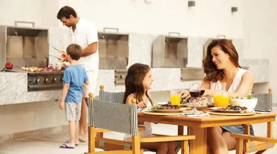 a woman and two children sitting at a table in a kitchen at Vive - Descansa - Disfruta in San Bartolo