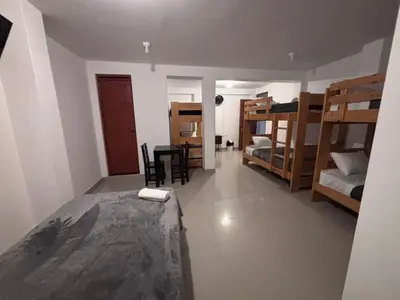 a bedroom with bunk beds and a dining room at Hotel Munay in Paracas