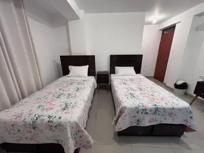 two beds sitting next to each other in a room at Hotel Munay in Paracas