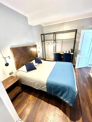 a bedroom with a large bed with blue pillows at Casa Montes San Blas in Cusco
