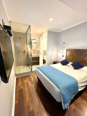a bedroom with a large bed and a bathroom at Casa Montes San Blas in Cusco