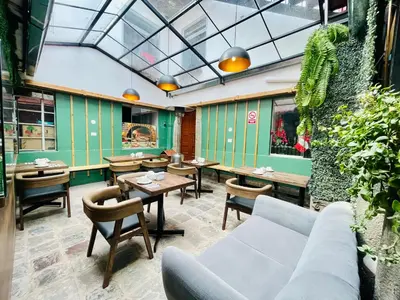 a restaurant with tables and chairs and a couch at Casa Montes San Blas in Cusco